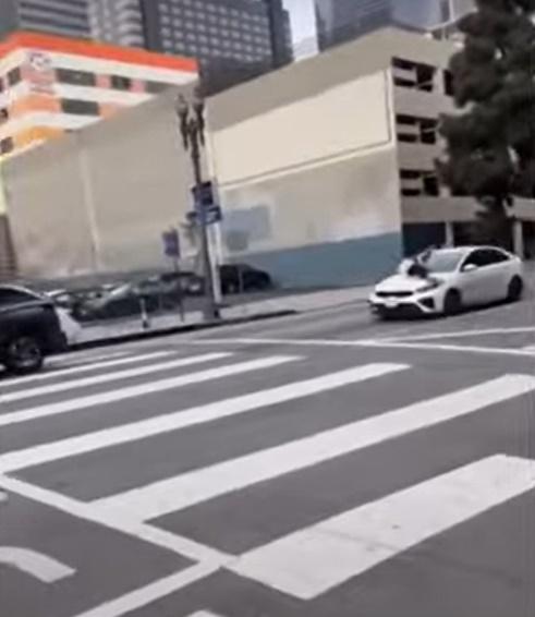 Ali抓住檔風玻璃下方的雨刷、緊緊伏在車頭蓋上,被竊賊「載」著在馬路上奔馳,險象環生。(YouTube)