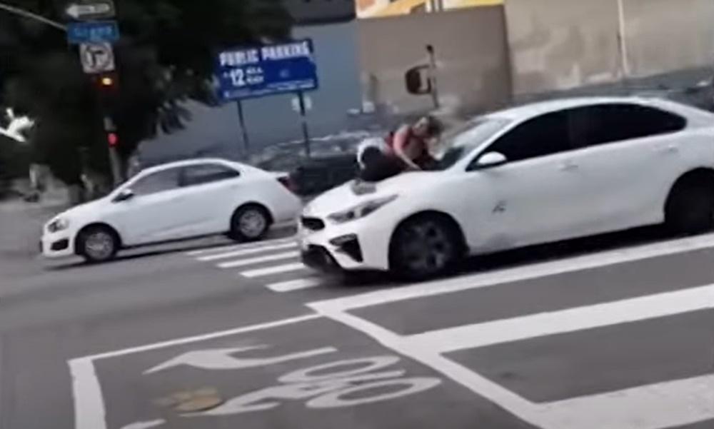 Ali抓住檔風玻璃下方的雨刷、緊緊伏在車頭蓋上,被竊賊「載」著在馬路上奔馳,險象環生。(YouTube)