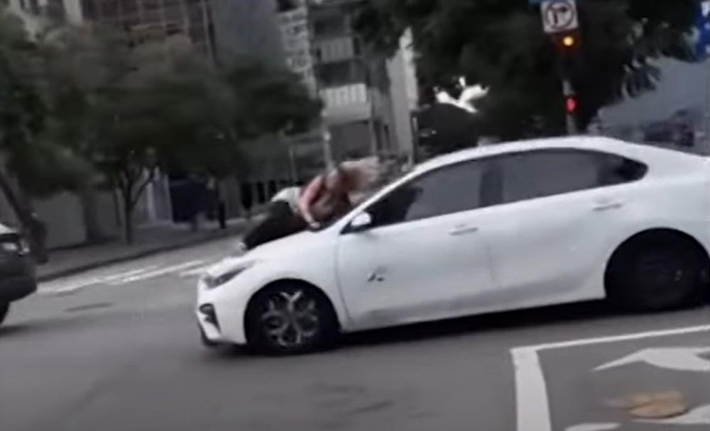 Ali抓住檔風玻璃下方的雨刷、緊緊伏在車頭蓋上,被竊賊「載」著在馬路上奔馳,險象環生。(YouTube)