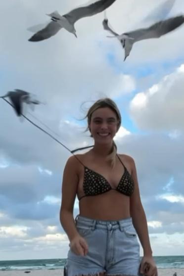 一隻海鷗突然俯衝下來,叼住她的比堅尼綁帶一扯。(IG)