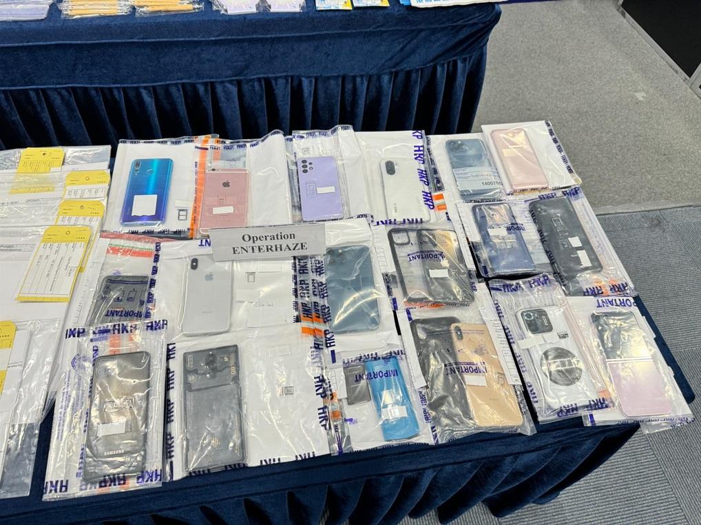 警方展示行動中檢獲證物,包括多部手提電話等。