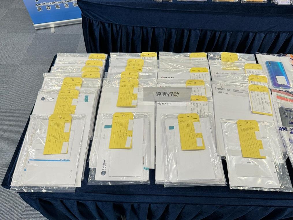 警方展示行動中檢獲證物,包括多部手提電話等。