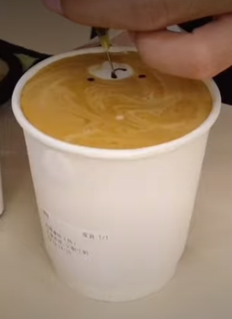 咖啡師正在咖啡上畫上小熊外貌。(圖源:You Tube)