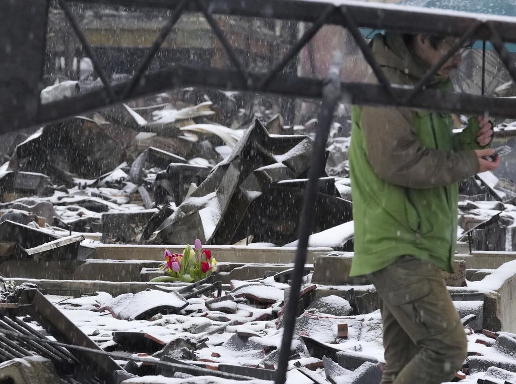 輪島市有民眾在燒毀的廢墟中放置鮮花悼念死者。(美聯社)