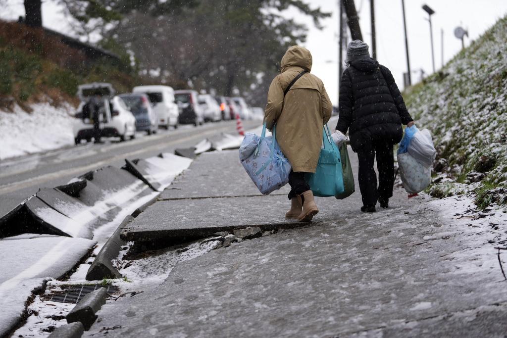 石川縣輪島市街上積雪,災民外出取物資。(美聯社)