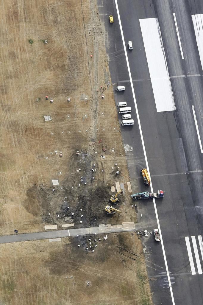 日航客機殘骸已移離,工作人員周日繼續清理跑道。(美聯社)