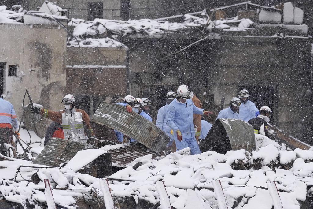 輪島市災區周一降雪,消防員繼續在廢墟中搜索。(美聯社)