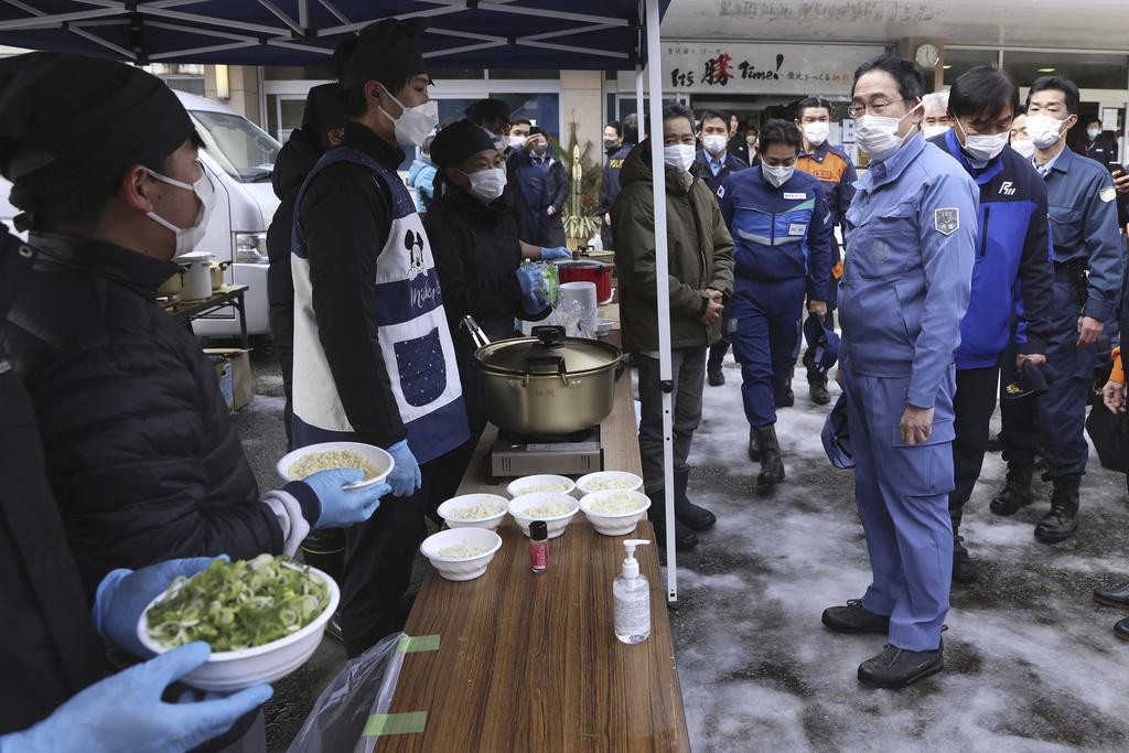 岸田文雄視察避難所烹食地方並與工作人員交流。(美聯社)