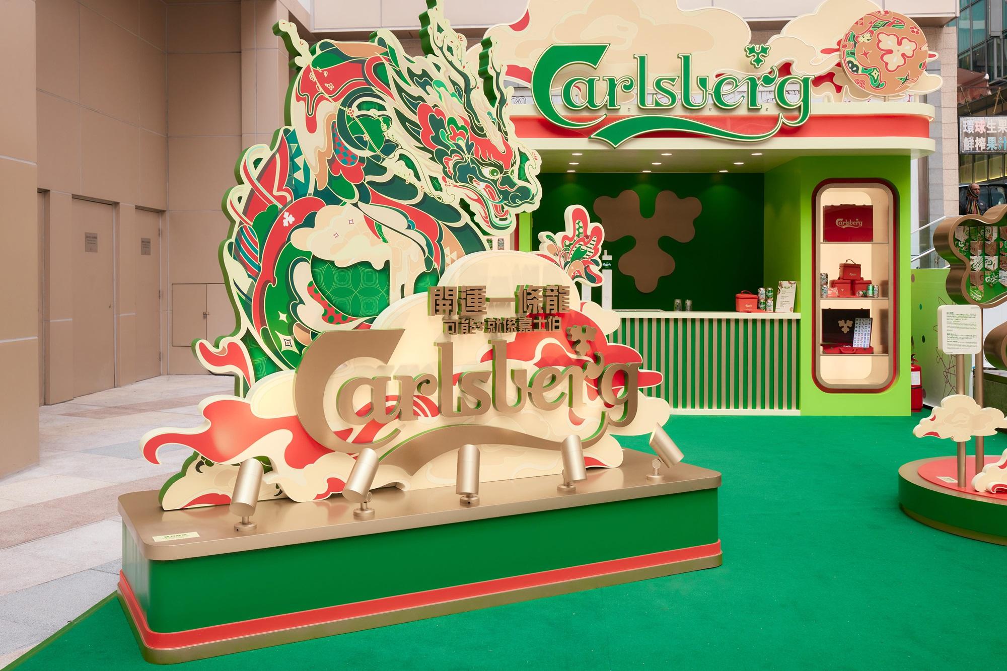 必影-嘉士伯龍年巨型舞龍裝飾|嘉士伯開運一條龍期間限定店以新春特別版紀念罐上的舞龍為主題,品牌的經典啤酒花圖案在限定店隨處可見,寓意新一年花開富貴,龍騰四海!此裝飾的龍身展現繽紛花紋,觸鬚綻放報春花和啤酒花,雙翅翩翩的形態,與現場的其他裝飾互相輝映。