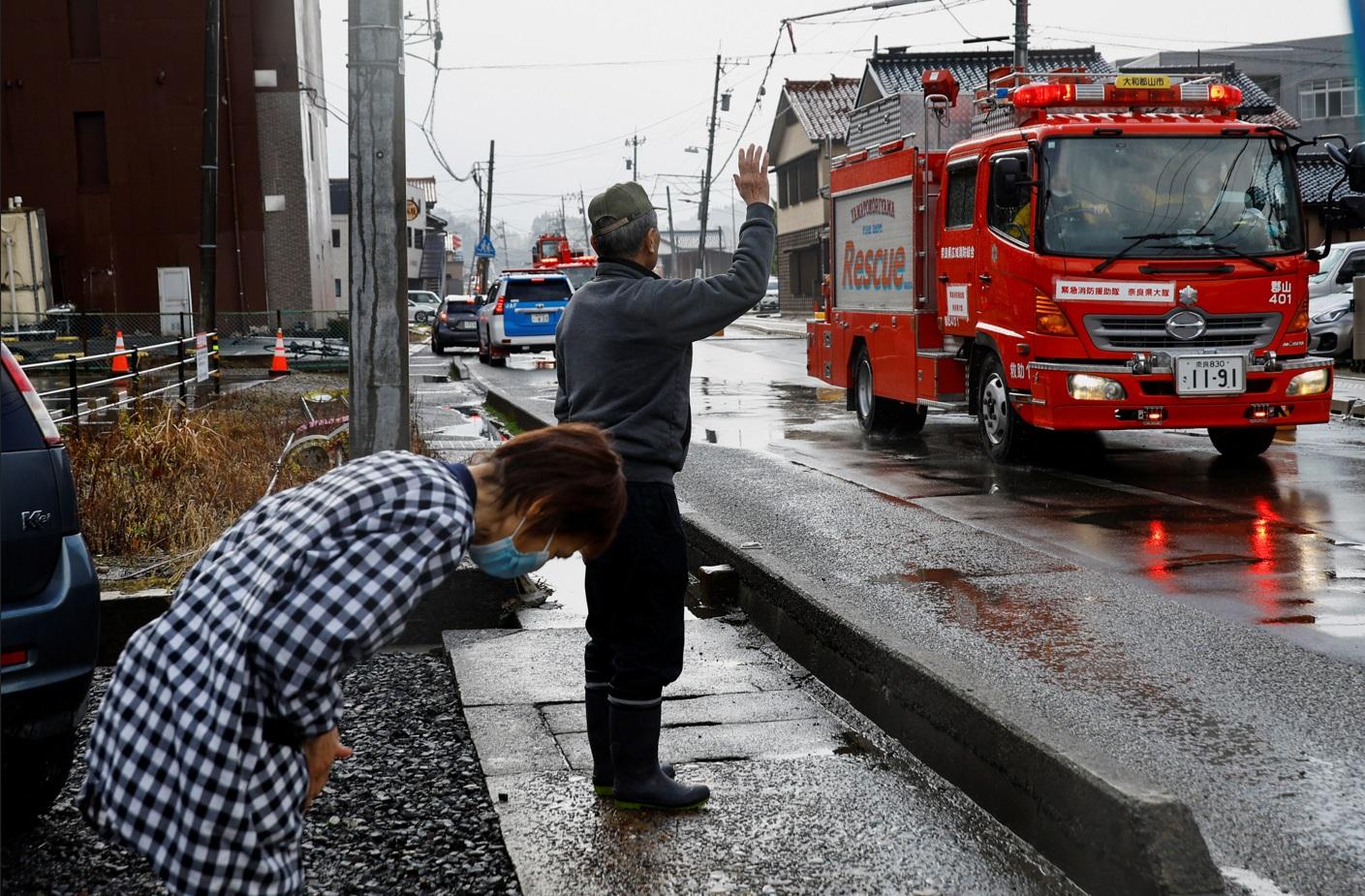 輪島市一對七旬夫婦見到消防車經過,便向其揮手致敬,並深深鞠躬致謝。(路透社)