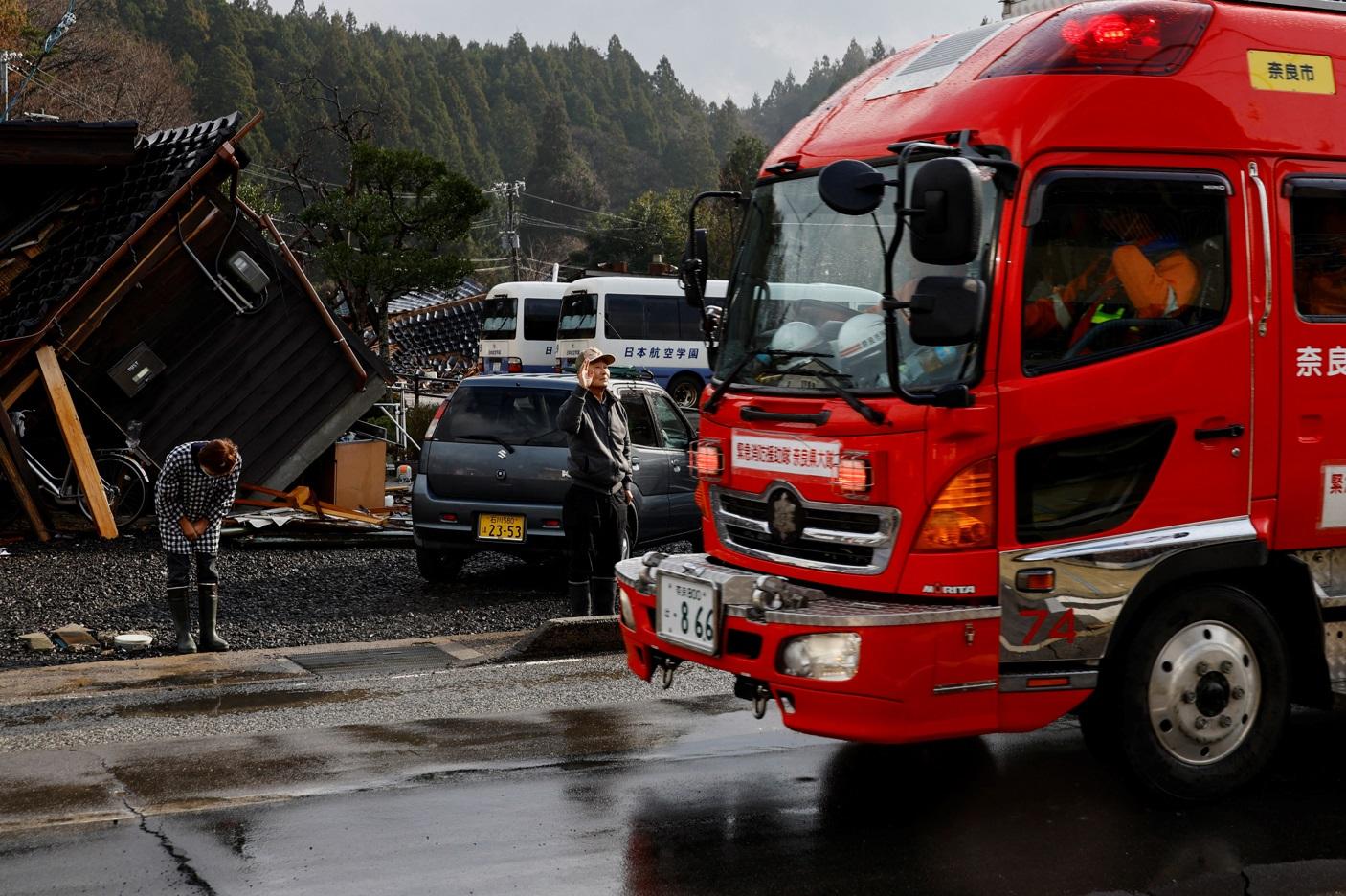 輪島市一對七旬夫婦見到消防車經過,便向其揮手致敬,並深深鞠躬致謝。(路透社)