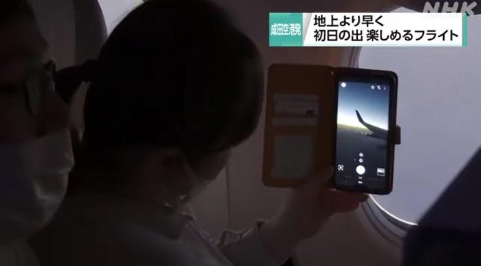 民眾在成田機場的新年首道曙光班機上觀看元旦日出。(互聯網)