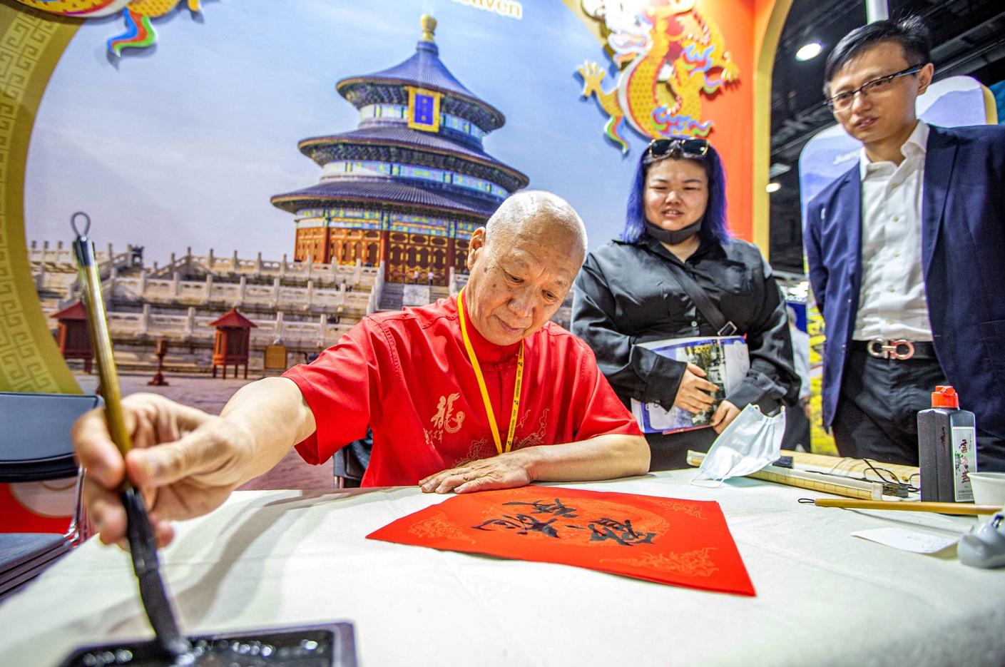 泰國曼谷近日舉行國際旅遊展,中國攤位工作人員示範寫書法。(新華社)