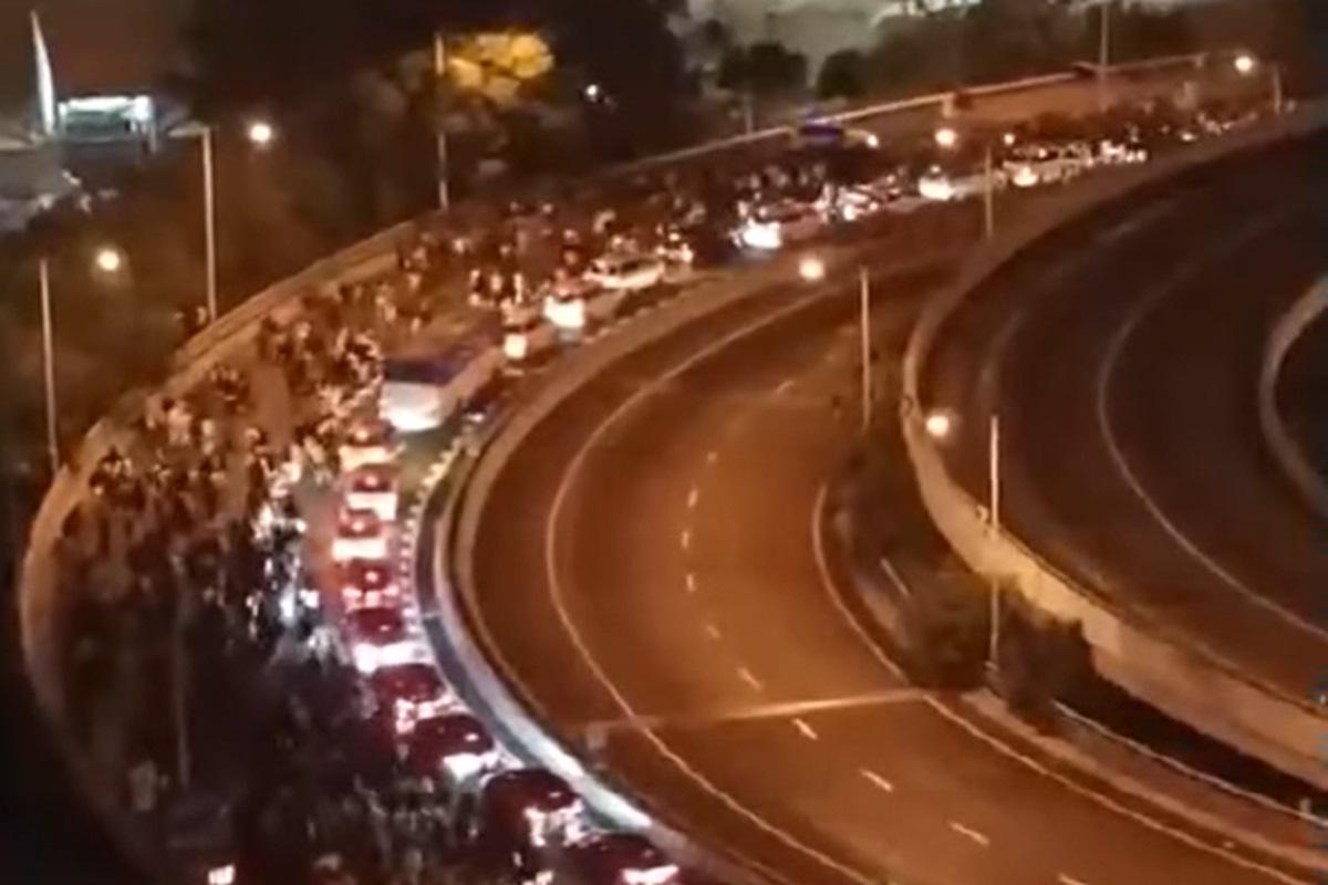 大批內地旅客在禁區中途下車步行往落馬洲管制站過關。(網上片段截圖)