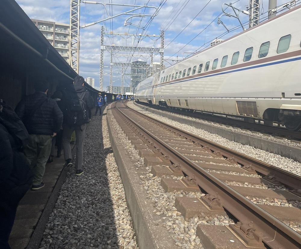 列車半路停駛,乘客沿路軌步行至附近車站。(互聯網)