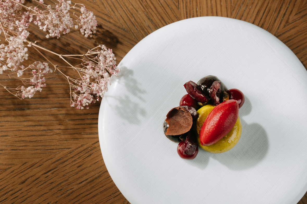 酒店行政 糕餅主廚 Carles Codina 窩心呈獻的精緻甜品「Tasmanian Cherry, Bourbon Vanilla, Dak Lak Chocolate, Pistachio」。