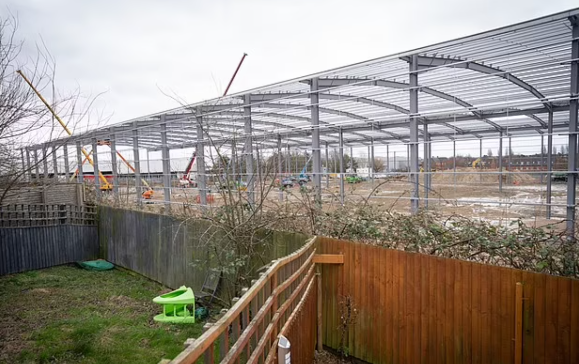 巨型貨倉緊貼著多間民居的後園。(互聯網)