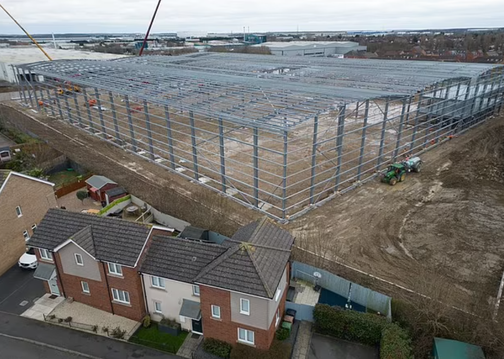 巨型貨倉緊貼著多間民居的後園。(互聯網)