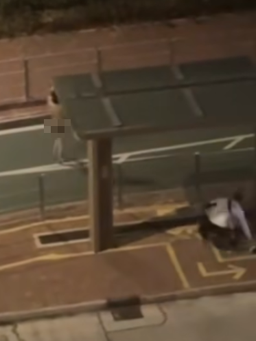 男子赫見女友舉動慌忙追上撿起衣物,再把她拉到欄杆邊,將衣物披在其身上蔽體。(網上影片)