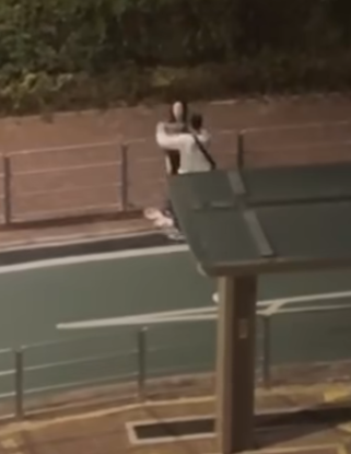 男子赫見女友舉動慌忙追上撿起衣物,再把她拉到欄杆邊,將衣物披在其身上蔽體。(網上影片)