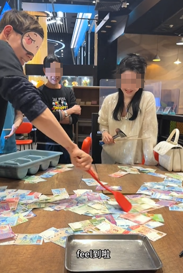 銅鑼灣一間餐廳的老闆娘於農曆新年期間為了犒賞員工,想出一個撈錢遊戲,將銀紙鋪滿桌上,限時15秒,員工可以用筷子、鑊鏟工具將銀紙撈到托盤上(影片截圖)