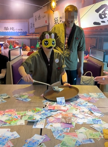 銅鑼灣一間餐廳的老闆娘於農曆新年期間為了犒賞員工,想出一個撈錢遊戲,將銀紙鋪滿桌上,限時15秒,員工可以用筷子、鑊鏟工具將銀紙撈到托盤上(影片截圖)