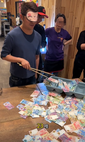 銅鑼灣一間餐廳的老闆娘於農曆新年期間為了犒賞員工,想出一個撈錢遊戲,將銀紙鋪滿桌上,限時15秒,員工可以用筷子、鑊鏟工具將銀紙撈到托盤上(影片截圖)