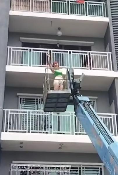 影片中,她站在升降台被緩緩升起,中途不忘向旁人打招呼,看上去完全不害怕。(FB)