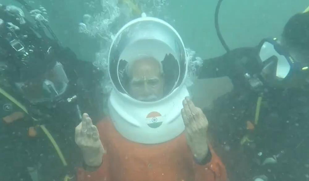 其後戴上頭盔形呼吸器,由多名潛水人員陪同下潛海底。(X)