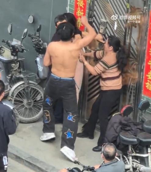 當時黑衣父親正護著一名年輕女子,上身赤膊的兒子出手打父親,母親正拉扯著該女子喊打。(微博)