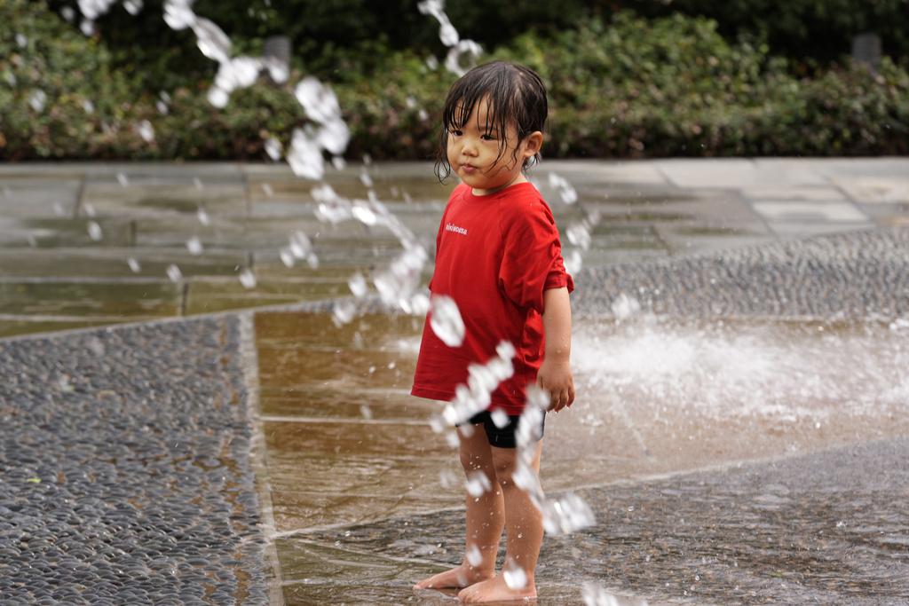 美國德州達拉斯周二天氣和暖,一名兩歲女童到公園戲水。(美聯社)
