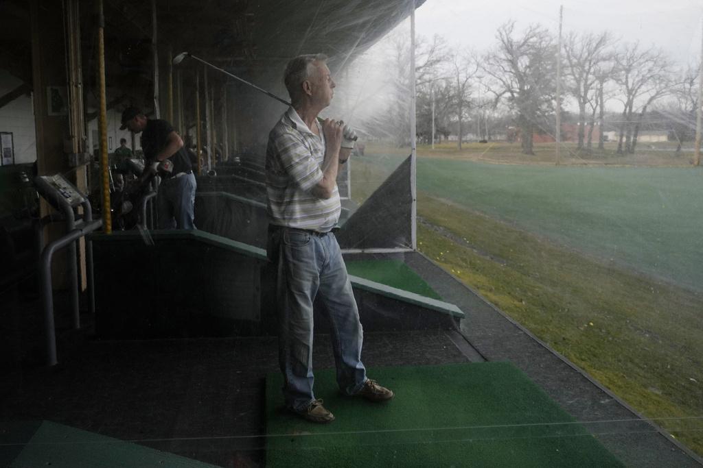 美國伊利諾伊州德斯普蘭斯周二有民眾趁和暖天氣,到高球場練波。(美聯社)