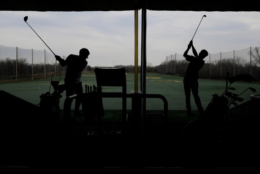 美國伊利諾伊州德斯普蘭斯周二有民眾趁和暖天氣,到高球場練波。(美聯社)