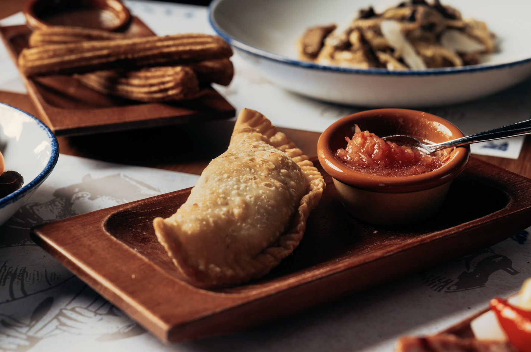 阿根廷餡餅Empanada,全人手包製配上清新番茄莎莎醬,饀料分別有:Carne牛肉餡餅,手切阿根廷牛肉配洋蔥橄欖;Pollo雞肉餡餅,烤雞配羅勒波椒;Cerdo豬肉餡餅,豬肉絲配香料青蘋果醬;及Fugazetta芝士餡餅,三重芝士配焦糖洋蔥。