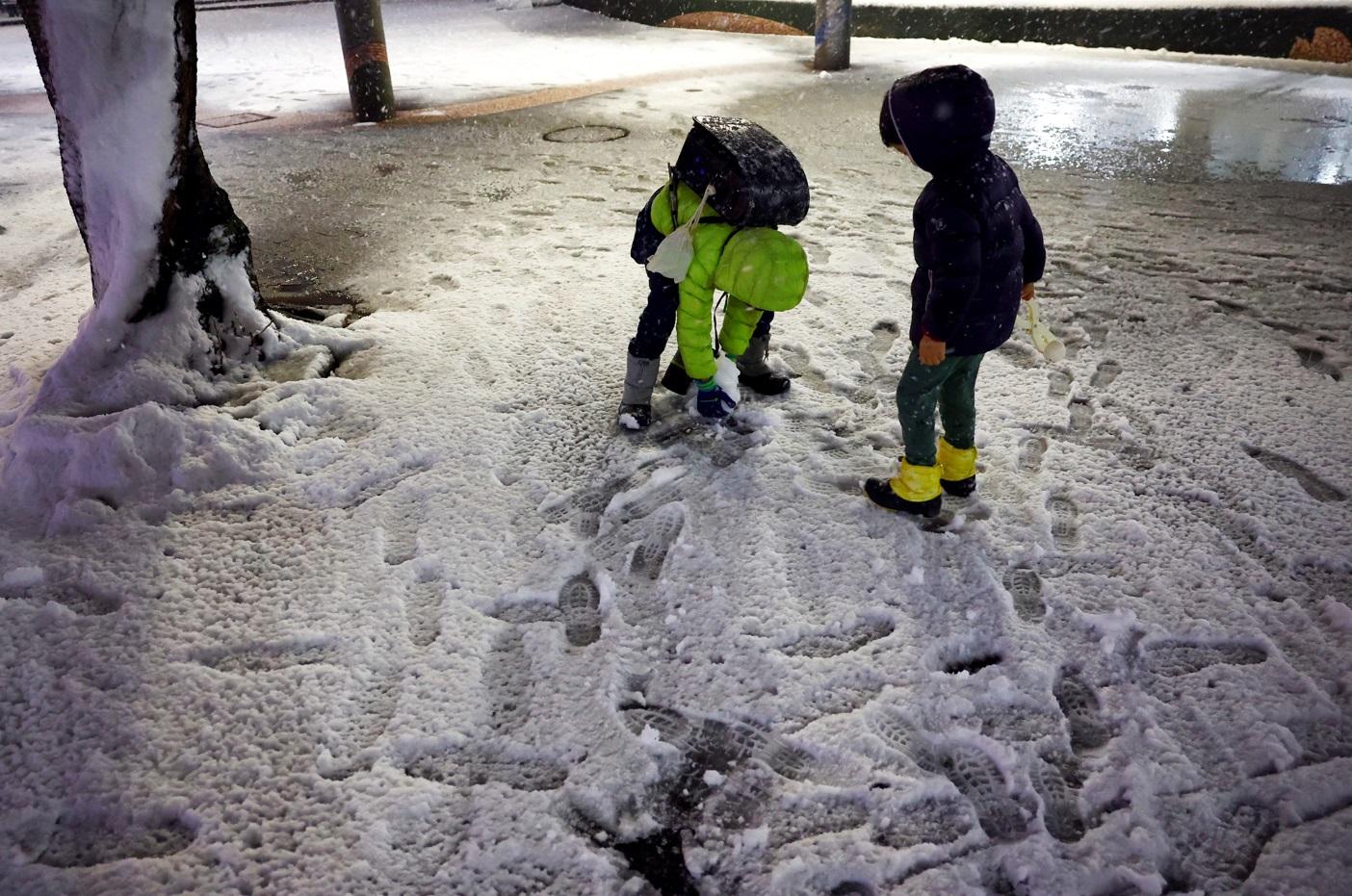 東京周一晚降雪,孩童在公園玩雪。(路透社)