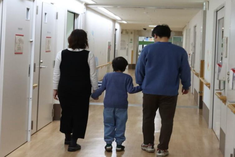 3月1日,男童牽著父母的手出院。(京都大學醫院圖片)
