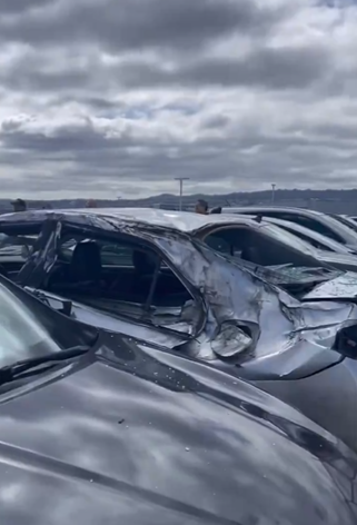 飛機脫落的輪胎落在機場員工使用的地面停車場,多架汽車受損。(影片截圖)