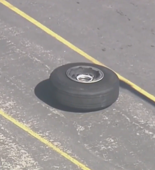 飛機脫落的輪胎落在機場員工使用的地面停車場,多架汽車受損。(影片截圖)