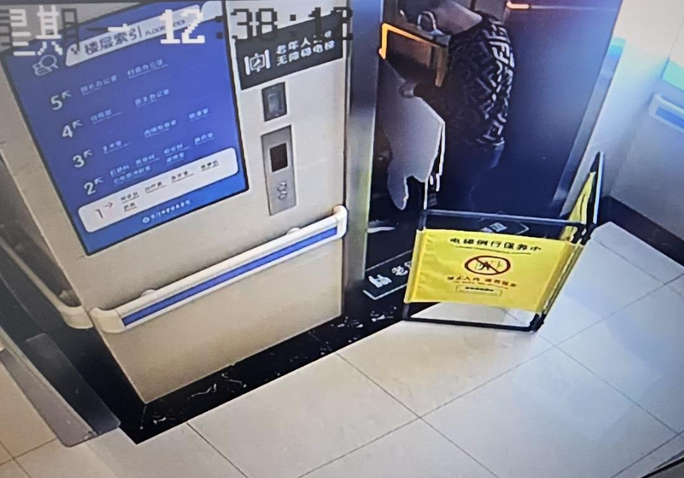 閉路電視拍下一名工人帶紙板人入升降機。