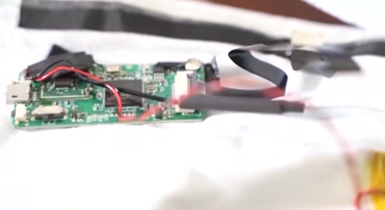 口罩設置鏡頭設備,從不同角度將偷拍到的試卷題目傳送至場外的「槍手」代考人員手中(央視截圖)