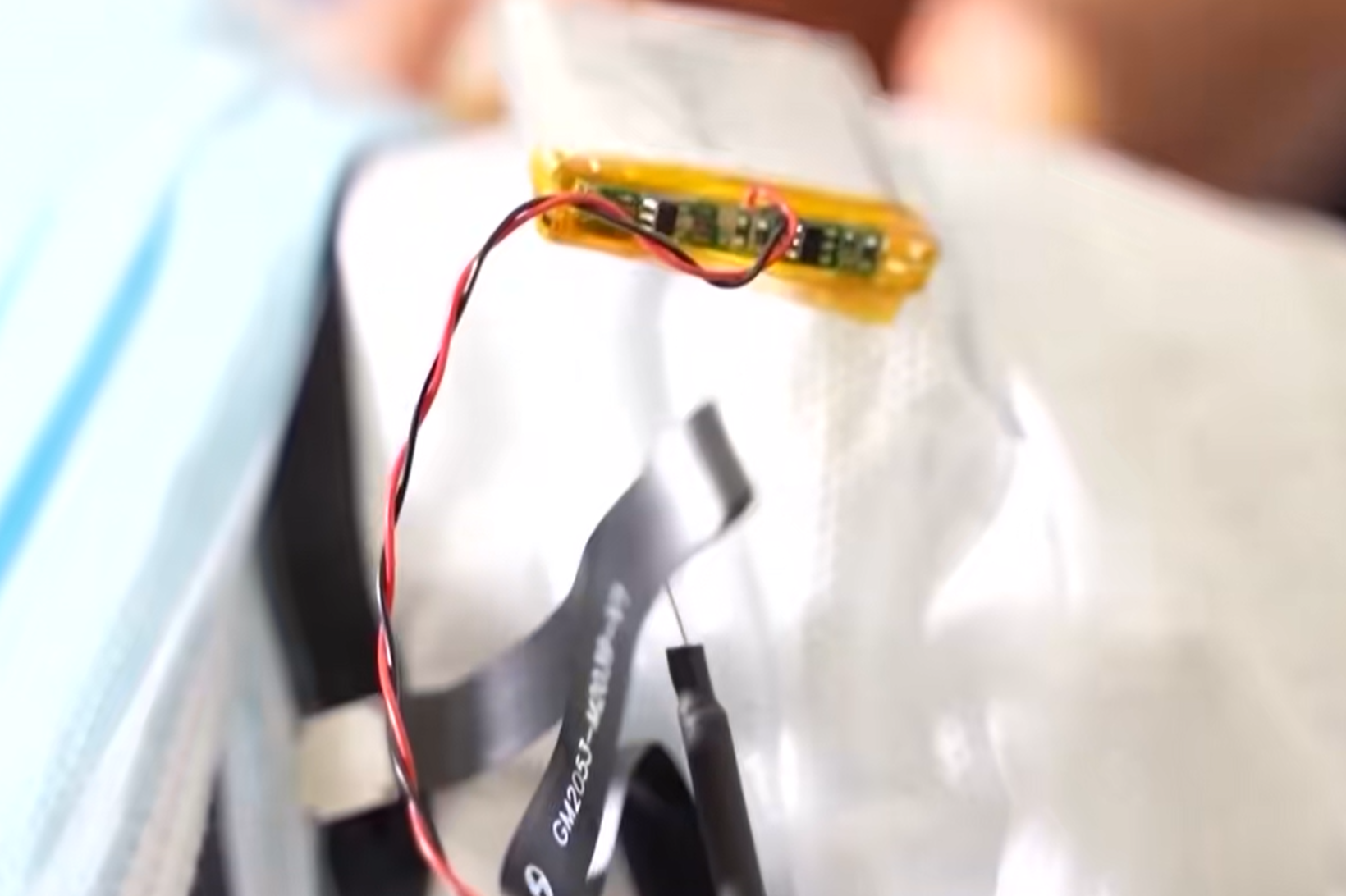 口罩設置鏡頭設備,從不同角度將偷拍到的試卷題目傳送至場外的「槍手」代考人員手中(央視截圖)