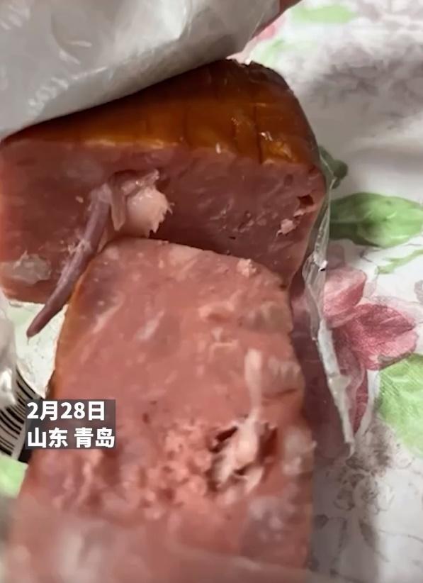 影片顯示,內地品牌「龍大肉食」的火腿已由中間切開,見有一條異物露出,上面還有細毛。(微博)