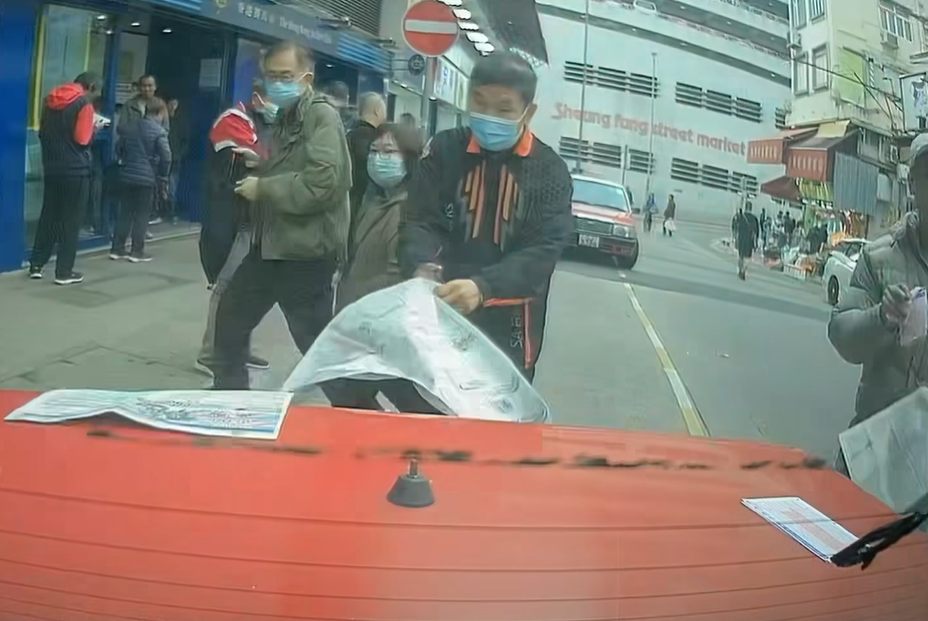 的士司機未有出言提醒便開車駛走,兩名馬迷隨即作出反應,將馬經及投注飛捉實,但仍有數張投注飛遺留在車尾冚上。(facebook群組「馬路的事討論區」影片截圖)