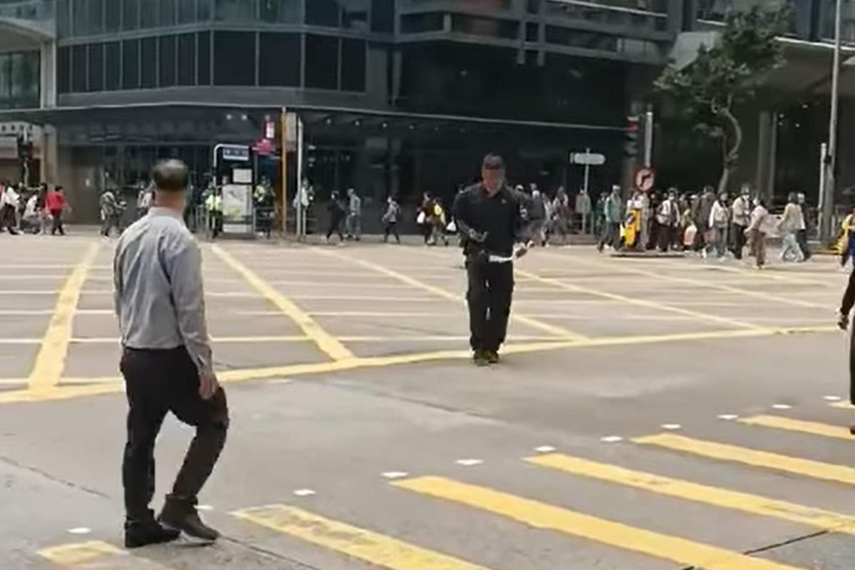 網上流傳片段顯示,一名男子在十字路口打斜過馬路遭截停和票控。(網上片段截圖)