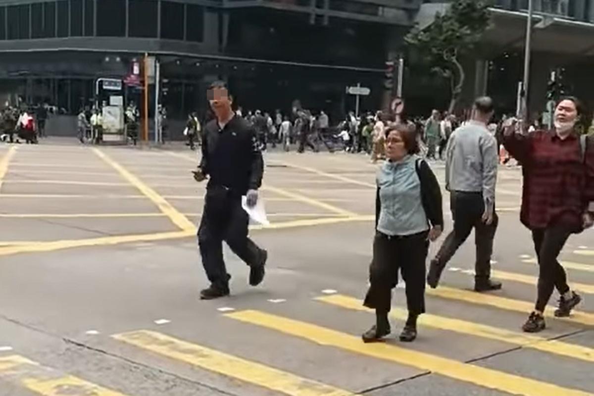 網上流傳片段顯示,一名男子在十字路口打斜過馬路遭截停和票控。(網上片段截圖)
