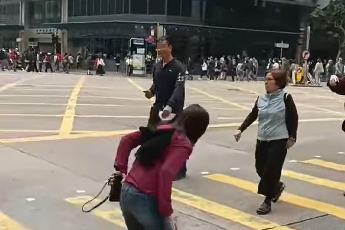 網上流傳片段顯示,一名男子在十字路口打斜過馬路遭截停和票控。(網上片段截圖)