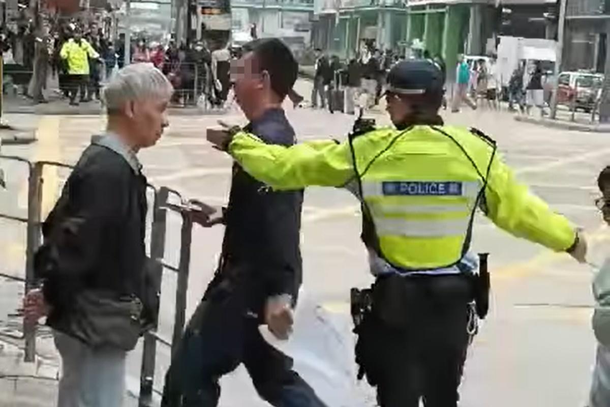 網上流傳片段顯示,一名男子在十字路口打斜過馬路遭截停和票控。(網上片段截圖)