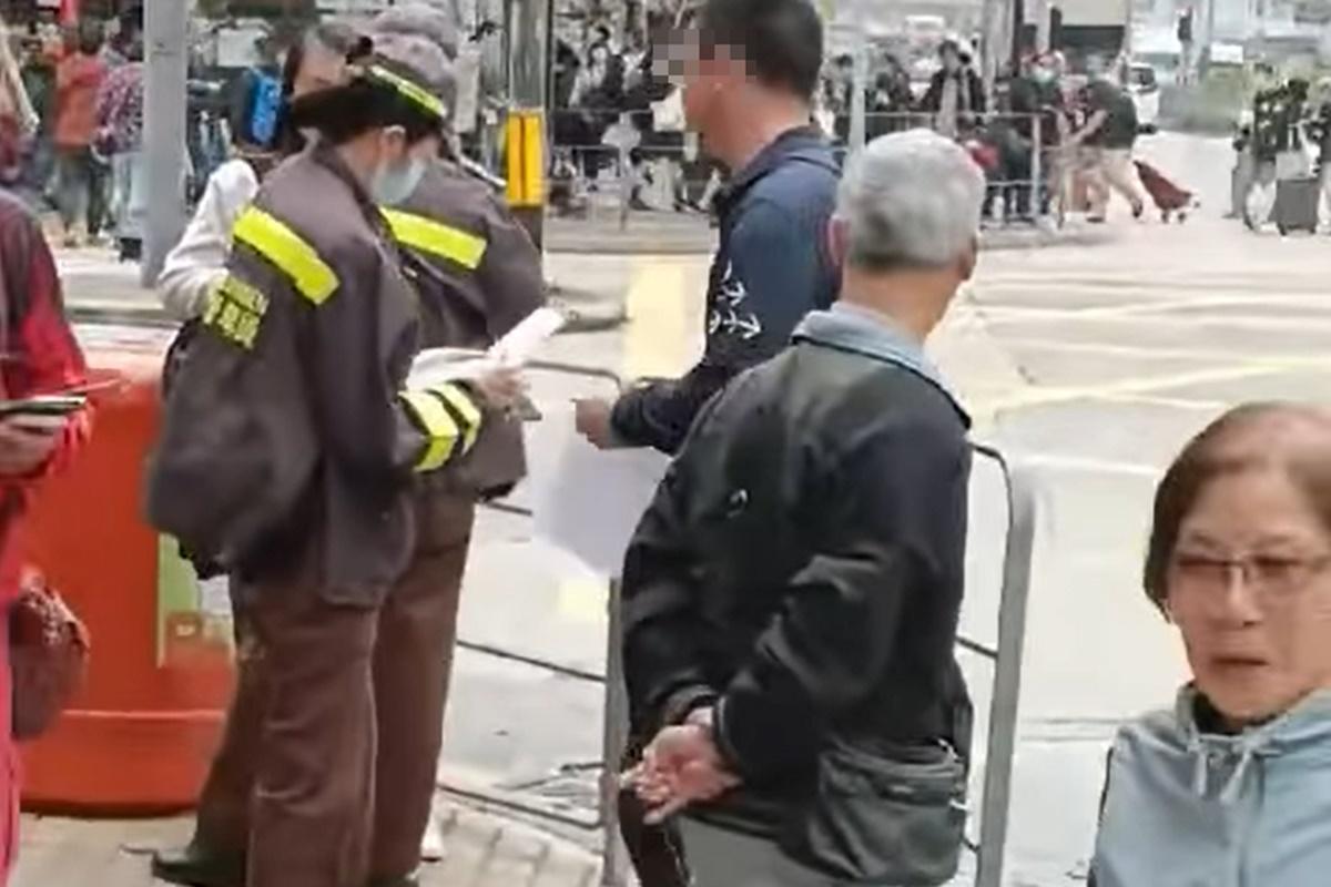 網上流傳片段顯示,一名男子在十字路口打斜過馬路遭截停和票控。(網上片段截圖)