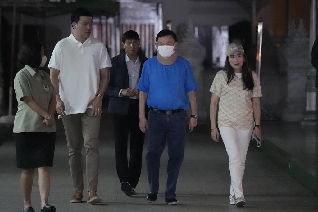 泰國前總理他信在女兒兼為泰黨黨魁佩通坦陪同下,到曼谷國柱神廟參拜,是他自獲得假釋以來首次公開露面。(美聯社)