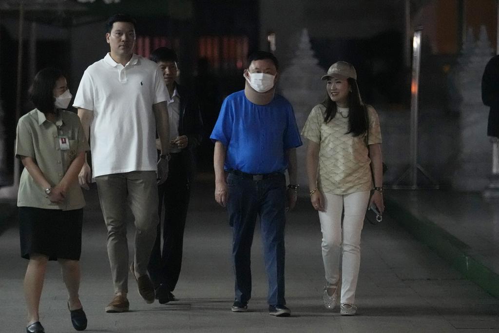 泰國前總理他信在女兒兼為泰黨黨魁佩通坦陪同下,到曼谷國柱神廟參拜,是他自獲得假釋以來首次公開露面。(美聯社)